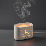 Decorative lamp with flame effect on a table, surrounded by a bottle and other items.