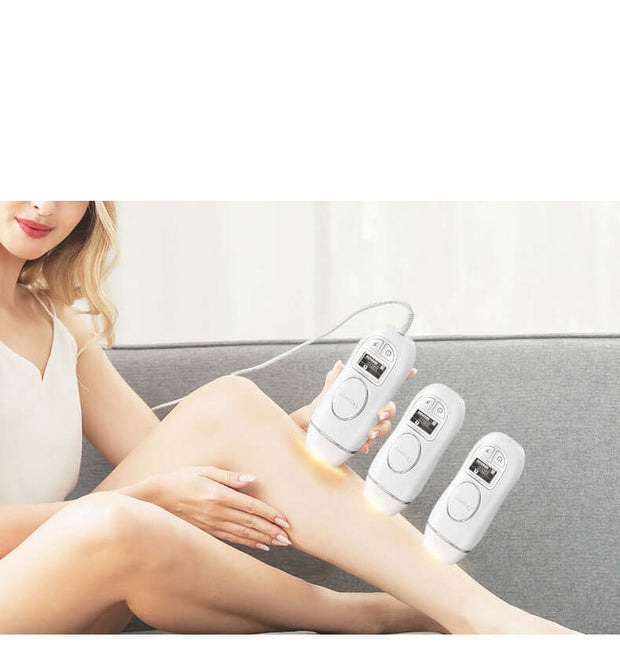 Woman using IPL laser hair removal device on her leg with two additional devices in view.